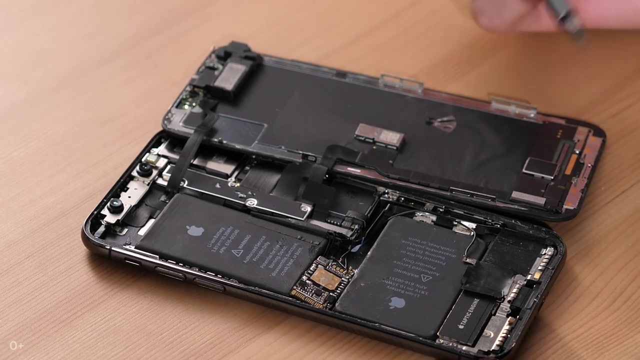 Otwarty iPhone z dodatkową płytką elektroniczną — kadr z materiału Navalny LIVE