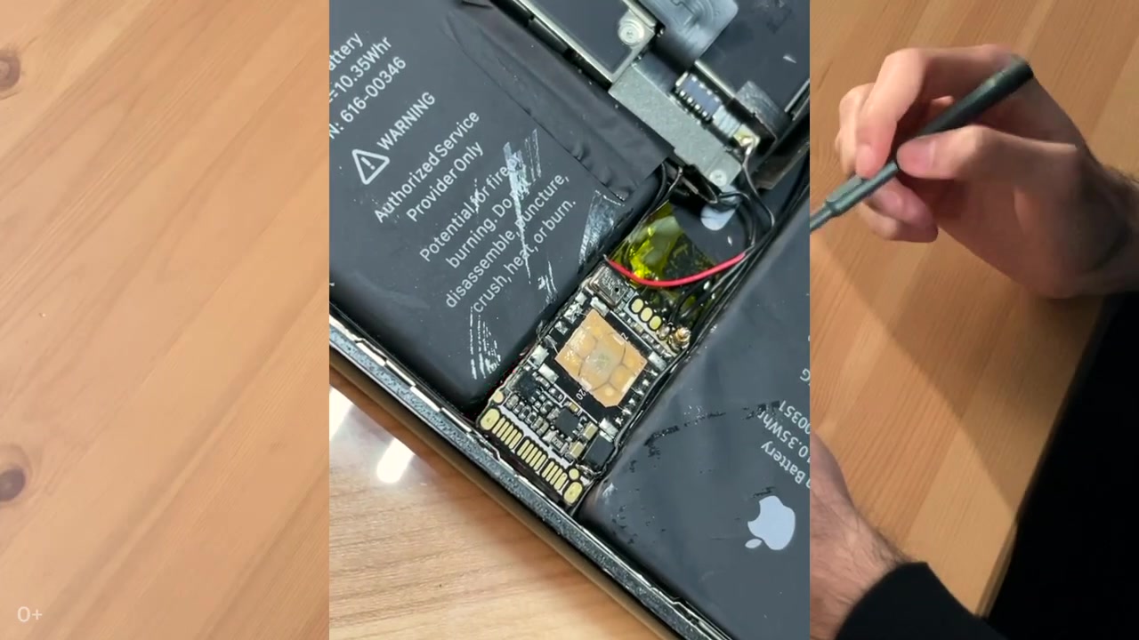 Zbliżenie dodatkowej płytki PCB i przewodów wewnątrz iPhone’a